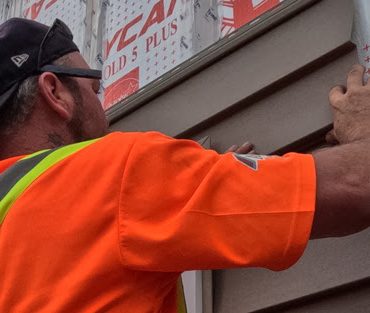 Image of Aurora Exteriors Inc Contractors installing siding on a residential home in Chatham Ontario on Faubert Drive.