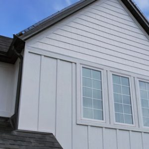 Second Story View of a Modern Farmhouse Style House with 3 Large Windows with White Grilles and Engineered Wood Exterior Trim.