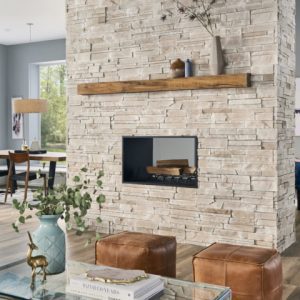 Stone siding used indoors to create an authentic looking stone fireplace in the center of the homes entertainment area, in sand colour.