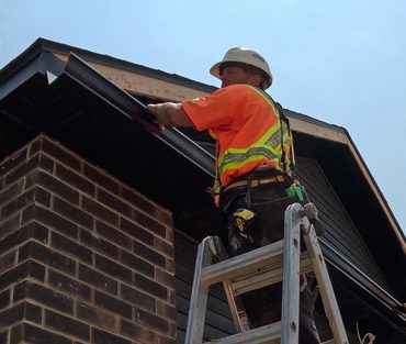 Aurora Contractors Working to Install Seamless Eavestrough to the roofline of a new construction home in Chatham-Kent.