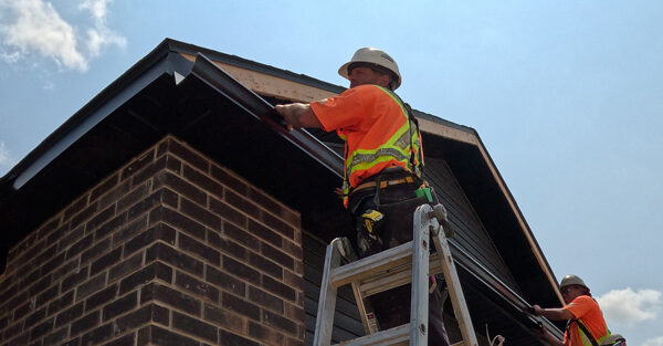 Seamless-Eavestrough-and-Gutter-Installation Aurora Contractors Working to Install Seamless Eavestrough to the roofline of a new construction home in Chatham-Kent.