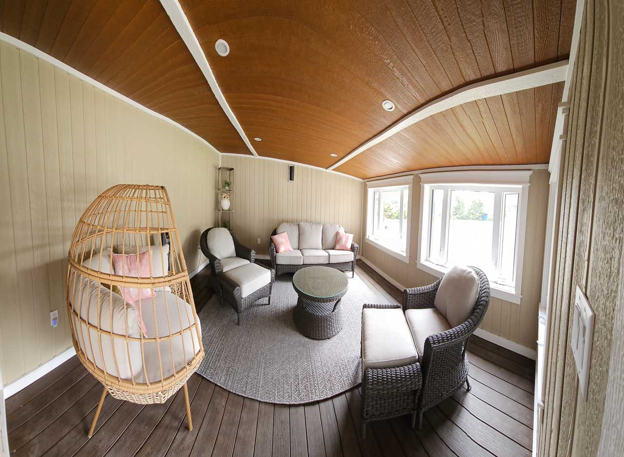 Expertly built 4 seasons room addition designed and constructed by Aurora Exteriors Inc using TruNorth Clubhouse Premium PVC boards in a dark walnut hardwood colour on the floors, an engineered wood in a creamy beige tone on the walls, and engineered wood in a wood colour on the ceiling.