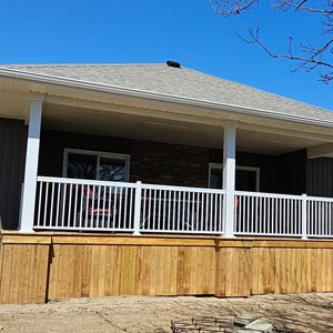Image of a pressure treated wood covered deck with stunning white aluminum railings and matching white aluminum post wraps constructed by deck contractors Aurora Exteriors Inc.