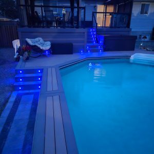 Composite deck with gemstone deck lighting, pictured at night with deck lights in a dark blue colour.