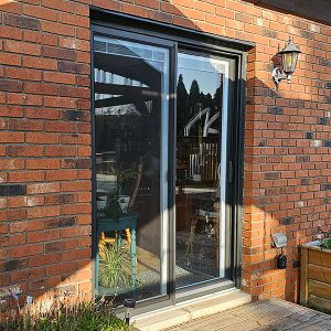 Replacement Sliding Glass Door with Rustic Granite Frame Installed by Aurora Exteriors as part of a Side Split Full Exterior Renovation