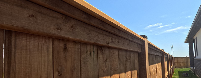 Traditional Vertical Pressure Treated Wood Fence with Black Aluminum Post Caps