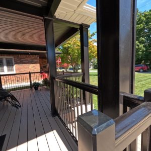 Black aluminum railings and column wraps on a covered front porch addition constructed by Aurora Exteriors Inc.