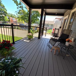 Clubhouse cobblestone composite deck surface on a covered porch addition constructed by Aurora Exteriors Inc.