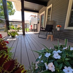 Clubhouse cobblestone composite deck surface on a covered porch addition constructed by Aurora Exteriors Inc.