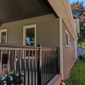 Manor Vinyl Siding contrasted with wolf white soffit, fascia and eavestrough installed by Aurora Exteriors to complete a covered porch addition and exterior reface project by Aurora Exteriors Inc.