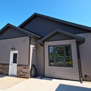 Dark Manor Vinyl Shakes, Stonecrest Grey Vinyl Siding and Sterling Stone Siding Wainscotting come together on a homes patio facing exterior wall to create timeless character.