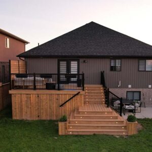 Wide Angle Shot of a Multi-tier Deck with Black Aluminum Railings, Built In Stair Lights, Planter boxes and hidden storage gate.